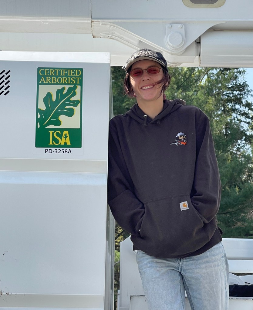 Katya standing next to bucket truck with ISA logo